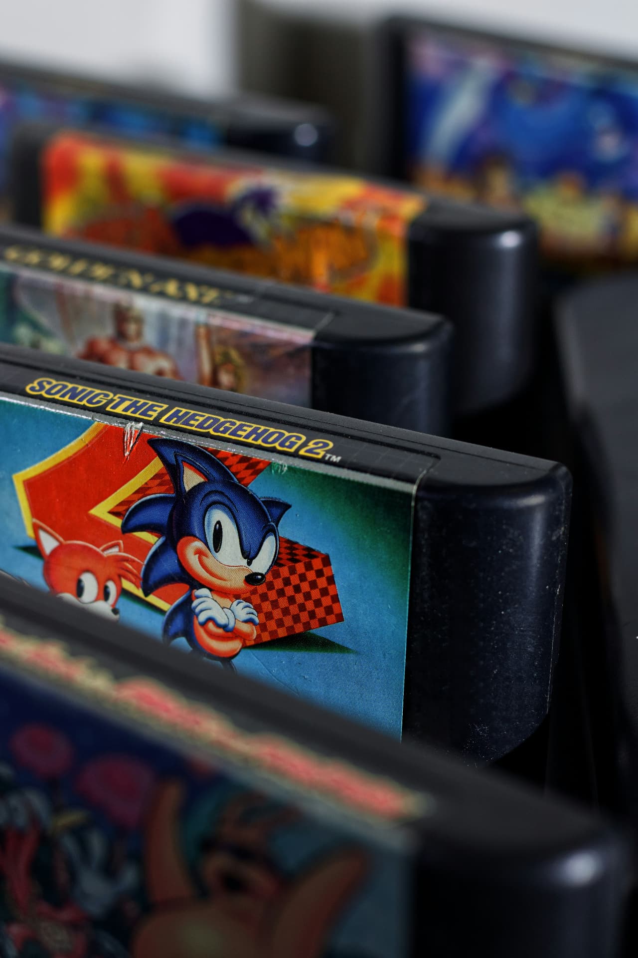 Row of Sega Genesis cartridges including Sonic the Hedgehog 2 standing in a display rack
